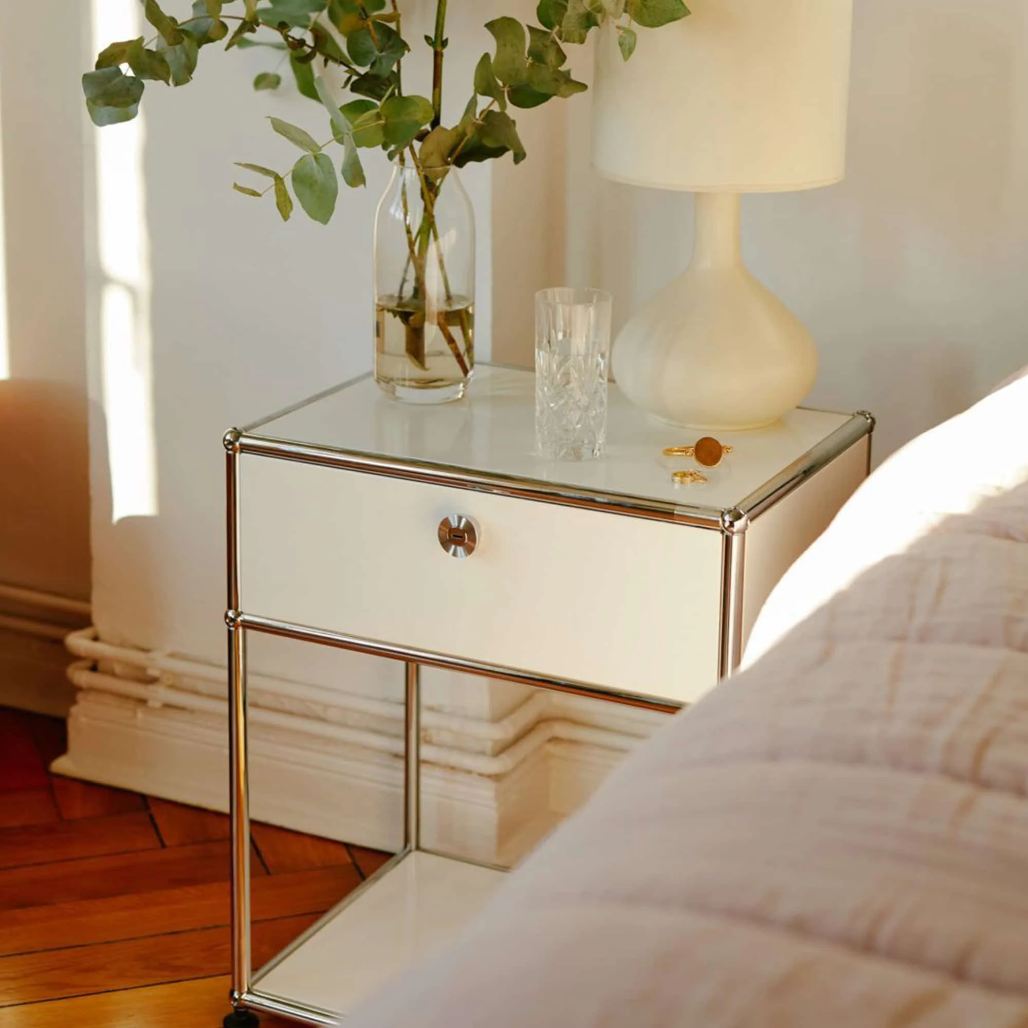 A traditional bedside table lamp on a nightstand next to a bed
